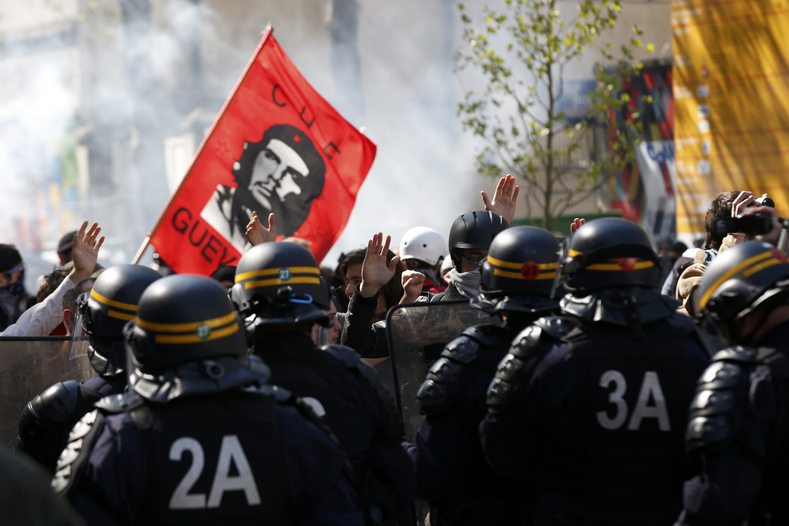 Youths raise their hands high to show that they do not hold bottles or stones as they pass French riot police during a protest against the French labour law proposal during the May Day labour union march in Paris, France, May 1, 2016. 