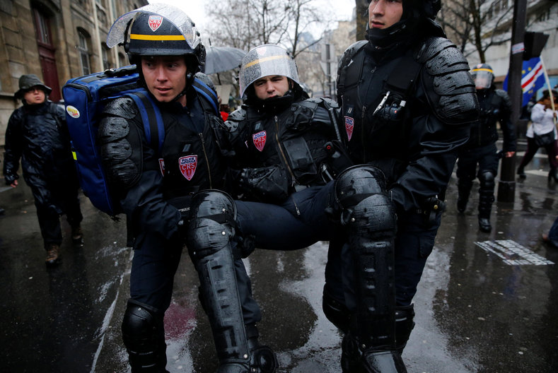 A French CRS riot police is evacuated during clashes with French high school and university students during a demonstration against the French labour law proposal in Paris, France, as part of a nationwide labor reform protests and strikes, March 31, 2016.