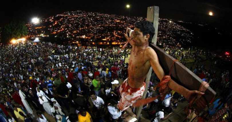 An actor is seen on the cross in a re-enactment of the crucifixion of Jesus Christ on Good Friday in Caracas' biggest slum of Petare April 6, 2012.