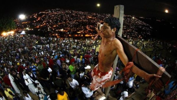 An actor is seen on the cross in a re-enactment of the crucifixion of Jesus Christ on Good Friday in Caracas' biggest slum of Petare April 6, 2012.