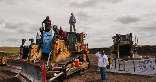 Demonstrators stand on heavy machinery after halting work on the Energy Transfer Partners Dakota Access oil pipeline, September 6, 2016