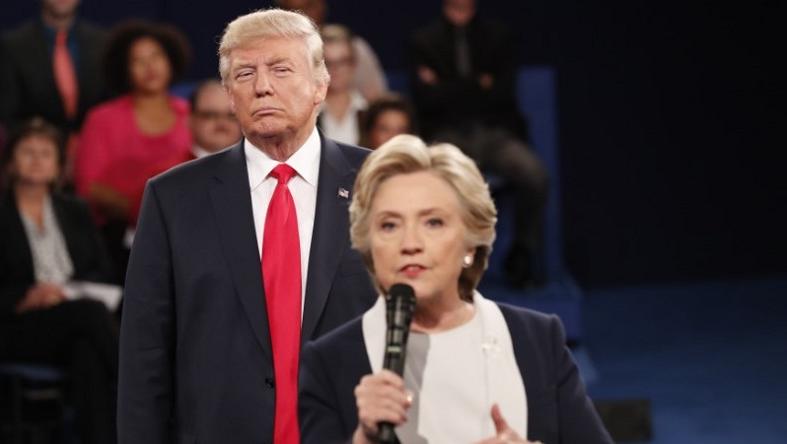 Donald Trump listens as Hillary Clinton answers a question from the audience.