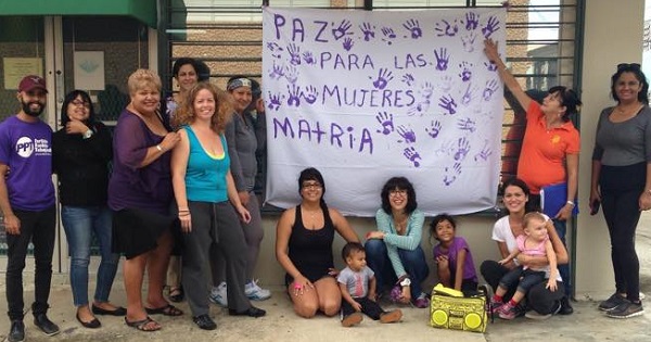 Participants in Proyecto Matria pose with a banner reading 