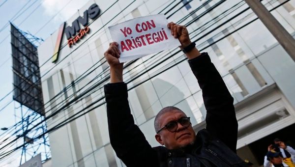 A demonstrator holds a sign that reads 