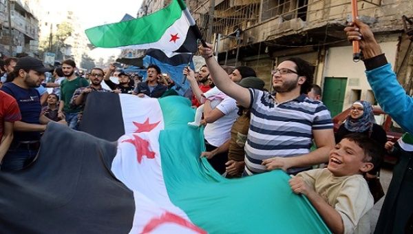 People carry Free Syrian Army flags in the rebel-held besieged al-Shaar neighborhood of Aleppo, Syria Oct. 20, 2016. 