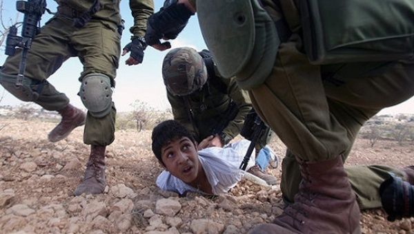 Palestinian youth is arrested by Israeli soldiers for throwing stones during a protest against the Jewish settlement of Karmei Tzur.