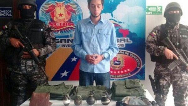 Venezuelan right-wing city councilman José Vicente García poses with the military equipment found at his car by security forces. 