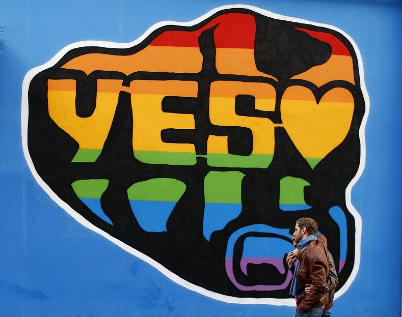 Men walk past a Yes vote campaign graffiti in central Dublin as Ireland holds a referendum on gay marriage, May 22, 2015.