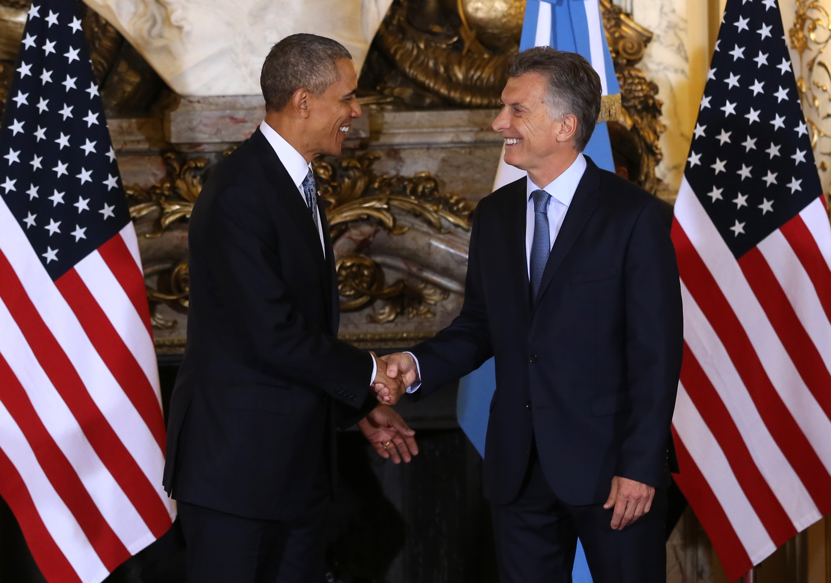 Macri and Obama shown engaged in a warm handshake during the U.S. president's visit to Argentina.