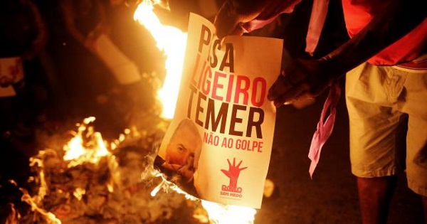 Members of Brazil's Landless Workers' Movement burn a poster with the image of Brazil's Interim President Michel Temer during a protest in Sao Paulo, Brazil, May 12, 2016.