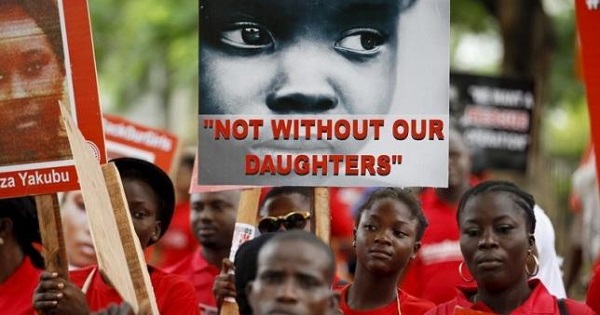 Bring Back Our Girls campaigners hold banners during a protest procession to bring attention to the abduction of girls in Chibok, along a road in Lagos Aug. 27, 2015.