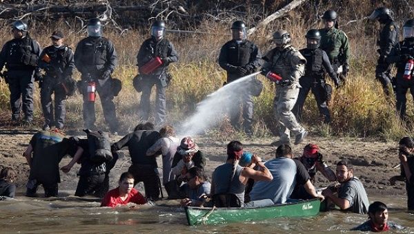 Police use pepper spray against protesters trying to cross a stream near an oil pipeline construction site adjacent to the Standing Rock Indian Reservation, North Dakota, Nov. 2, 2016.