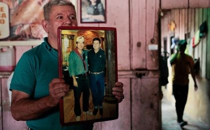 Marlo Laguna, 57, holds a picture of himself with Nicaragua's President Daniel Ortega in his house in Ortega's childhood town of La Libertad, Nicaragua October 22, 2016.