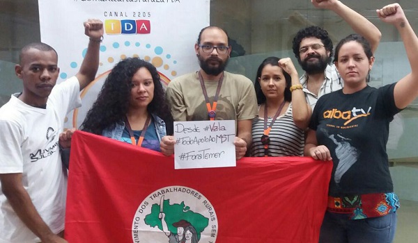 Workers from ALBA TV hold up a flag of the Brazil’s Landless Workers' Movement in a show of solidarity with the organization, Caracas, Venezuela, Nov. 4, 2016.
