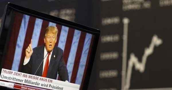 A TV screen showing U.S. President-elect Donald Trump pictured in front of the German share price index, DAX board, at the stock exchange in Frankfurt, Germany.