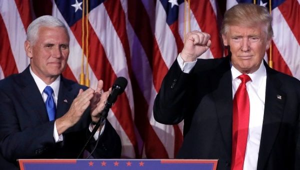 U.S. President-elect Donald Trump gestures as Vice President-elect Mike Pence applauds (L) at their election night rally in Manhattan.