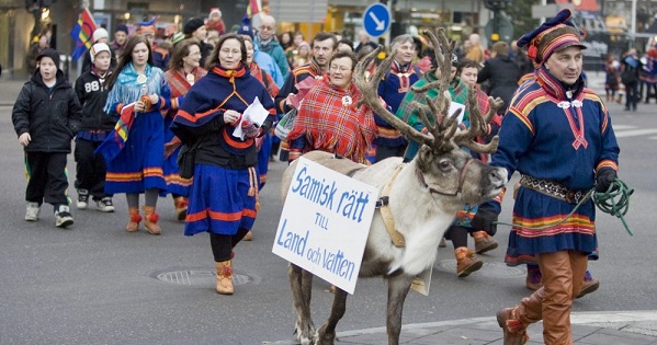 Sami protesters, dressed in traditional clothes, walk through downtown Stockholm.