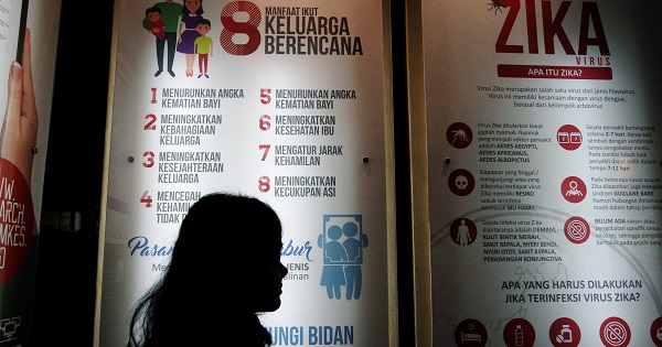 A woman stands near a poster explaining about the Zika virus at the Ministry of Health office in Jakarta, Indonesia Sept. 2, 2016.