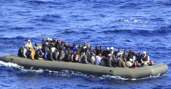Migrants in a boat during a rescue operation by Italian navy ship San Marco off the coast to the south of the Italian island of Sicily.