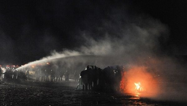 Police use a water cannon to put out a fire started by protesters during a protest against plans to pass the Dakota Access pipeline near the Standing Rock Indian Reservation, near Cannon Ball, North Dakota.