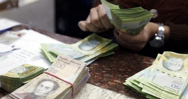 A cashier counts bolivars at a money exchange in Caracas, Venezuela.