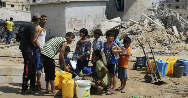 Palestinian children collect water in Khan Yunis, in the southern Gaza Strip, during the 2014 Israeli Invasion.