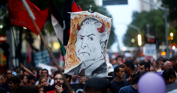 A demonstrator holds a banner with a drawing representing Michel Temer in Rio de Janeiro, Brazil, Nov. 25, 2016.