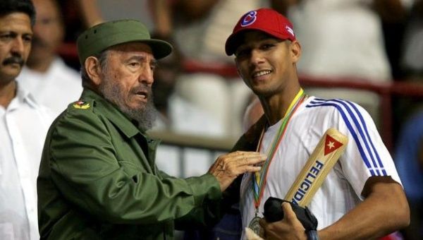 Then-Cuban President Fidel Castro (L) hands out a baseball bat to Cuban player Yulieski Gourriel in Havana in this March 21, 2006 file photo.
