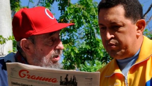 Former Cuban leader Fidel Castro and Venezuela's Hugo Chavez read a copy of the Cuban Communist Party newspaper 