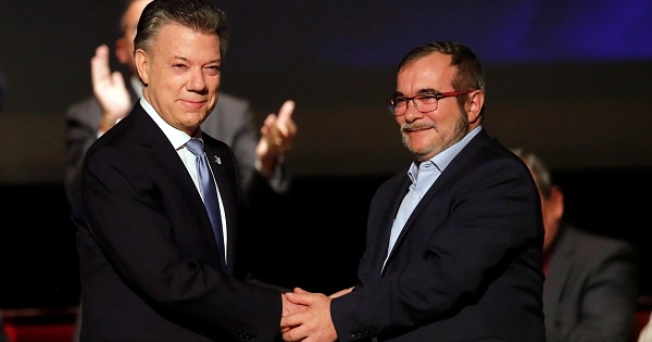 Colombia's President Juan Manuel Santos and FARC leader Rodrigo Londono, known as Timochenko, shake hands after signing a peace accord in Bogota, Nov. 24, 2016.