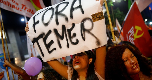 A woman holds a banner that reads 