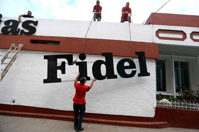 Workers hang a sign to Cuba's late President Fidel Castro in Santa Clara, Cuba, Nov. 30, 2016.
