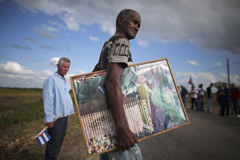 Jose Ramos, 69, holds an image of Fidel Castro as he awaits the caravan carrying Castro's ashes in Colon, Cuba, Nov. 30, 2016.
