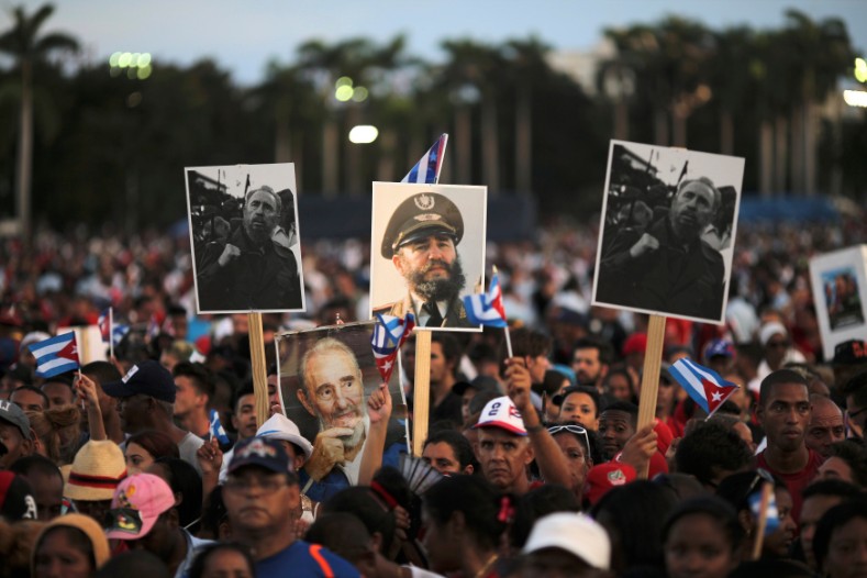 People hold images of Cuba's late President Fidel Castro as they wait for the arrival of the caravan carrying his ashes in Santiago de Cuba, Dec. 3, 2016. 