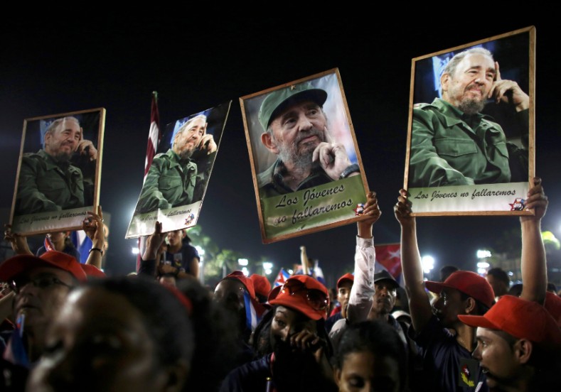 People hold up images of former Cuban leader Fidel Castro at a tribute to Fidel Castro in Santiago de Cuba, Dec. 3, 2016. 
