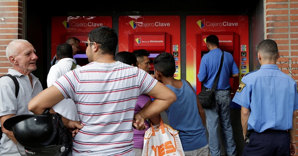 People line up to withdraw cash from an ATM outside a Banco de Venezuela branch in Caracas, Nov. 23, 2016.