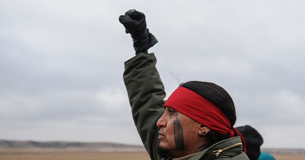 North Dakota Indigenous demonstrator raises his fist in victory.