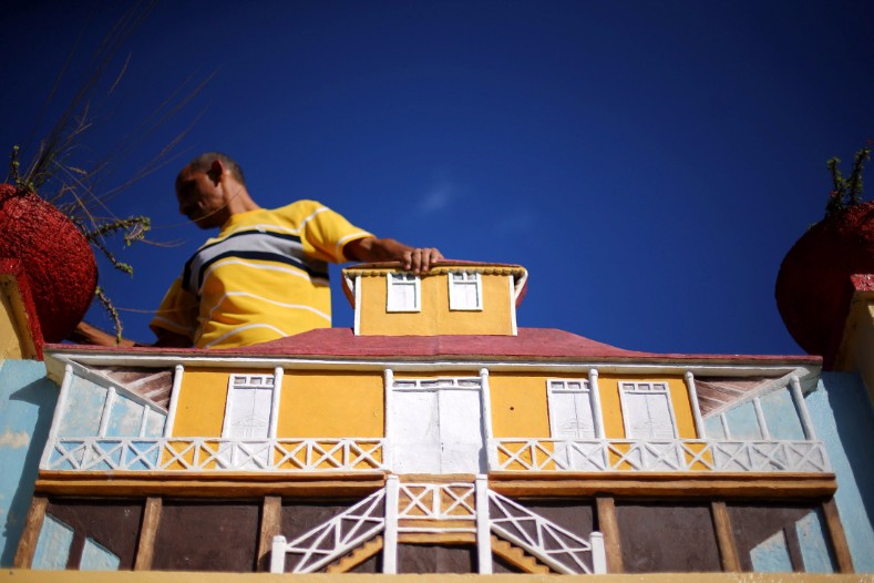 A man stands next to a model of the house where Cuba's former President Fidel Castro was born, in Biran.