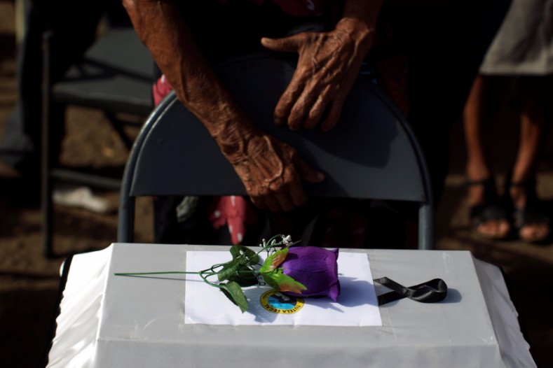 People observe the remains of their relatives as they participate in a ceremony to commemorate the 35th anniversary of the El Mozote massacre in El Mozote, El Salvador, Dec. 10, 2016. 