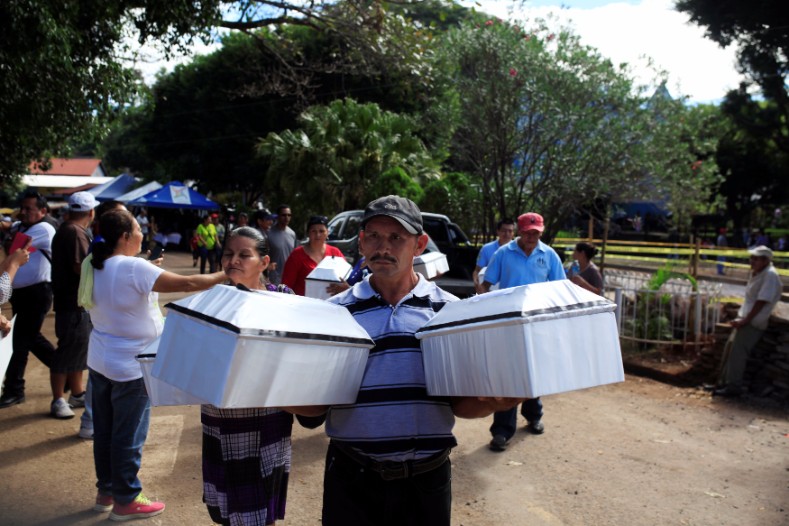 A man carries the remains of a relative during a ceremony to commemorate the 35th anniversary of El Mozote massacre in El Mozote.