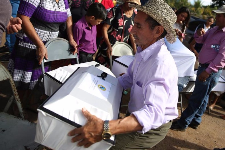 Eustaquio Martínez Vigil carries the remains of one of his children during the ceremony to commemorate victims of the El Mozote massacre, Dec. 10, 2016.