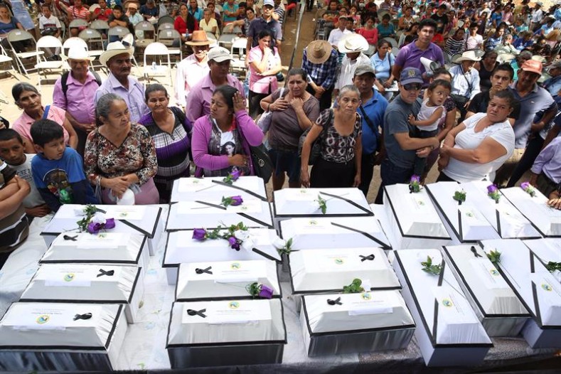 Family members of victims of the El Mozote massacre present the remains of some of the victims in white coffins, commemorating 35 years since the bloody event. 