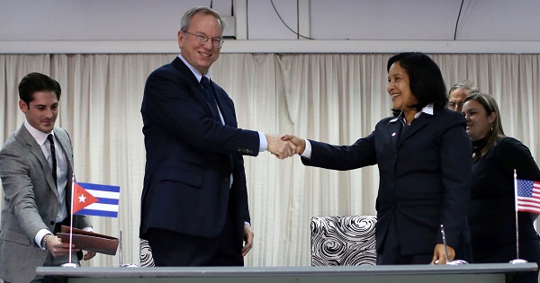 Eric Schmidt, chairman of Alphabet Inc. and Mayra Arevich Marin, president of ETECSA, shake hands after signing documents in Havana.