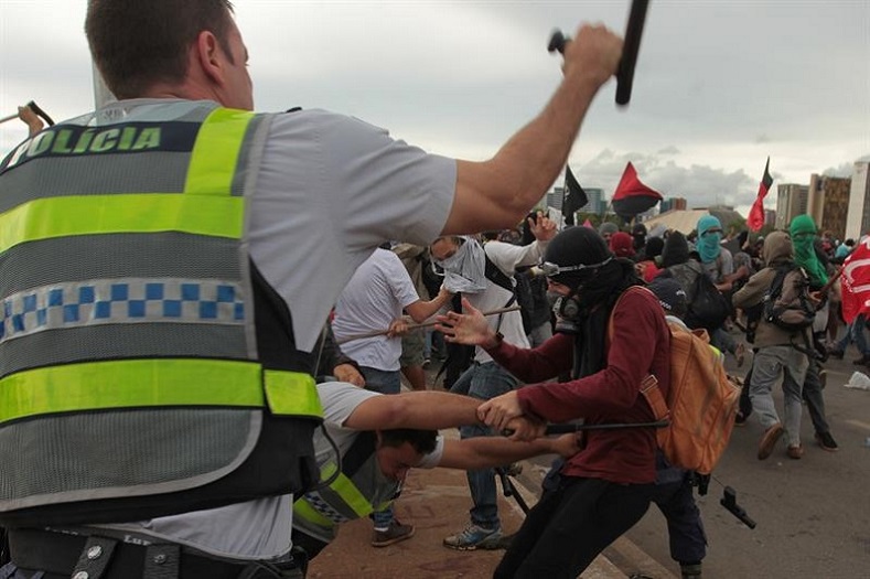 Riot police attack an anti-austerity protester.