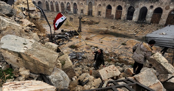 Syrian soldier with the national flag inside Aleppo's Umayyad Mosque.