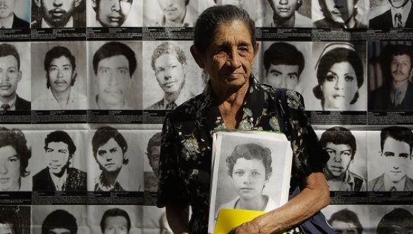 Apolonia Escamilla holds a portrait of a family member at the Monument to Memory and Truth in San Salvador, Jan. 15, 2013.