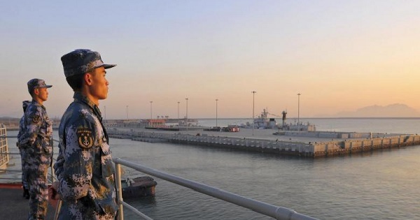 Chinese naval soldiers stand guard on China's first aircraft carrier Liaoning, as it travels towards a military base in Sanya, Hainan province, Nov. 30, 2013.
