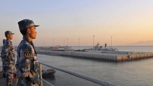 Chinese naval soldiers stand guard on China's first aircraft carrier Liaoning, as it travels towards a military base in Sanya, Hainan province, Nov. 30, 2013. 