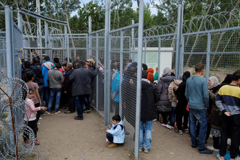 Migrants wait to cross the border at a makeshift camp at the Serbian-Hungarian border near the village of Horgos Serbia May 19 2016.