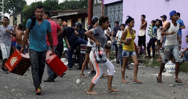 People carry goods taken in La Fria, Venezuela, Dec. 17, 2016.